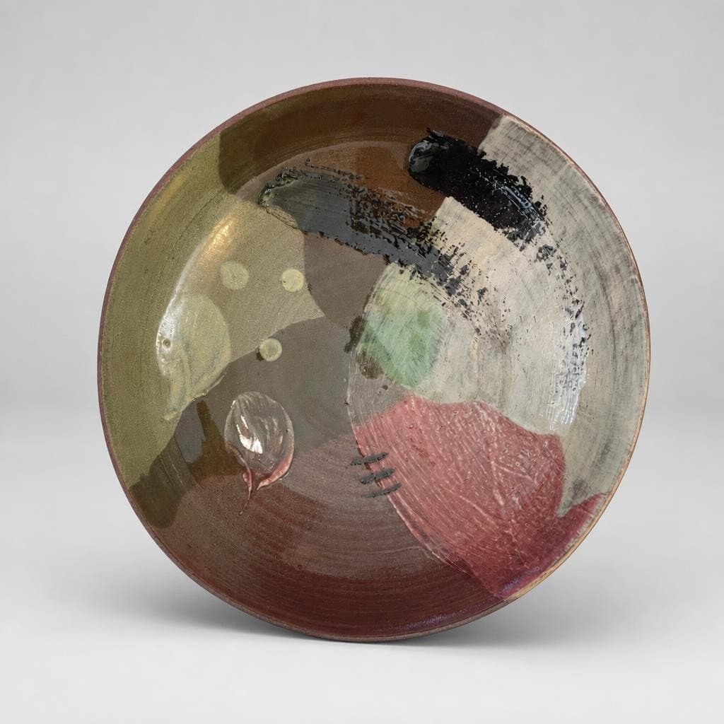 Low, wide, slip-decorated, terracotta serving bowl with angled walls in translucent green and wine