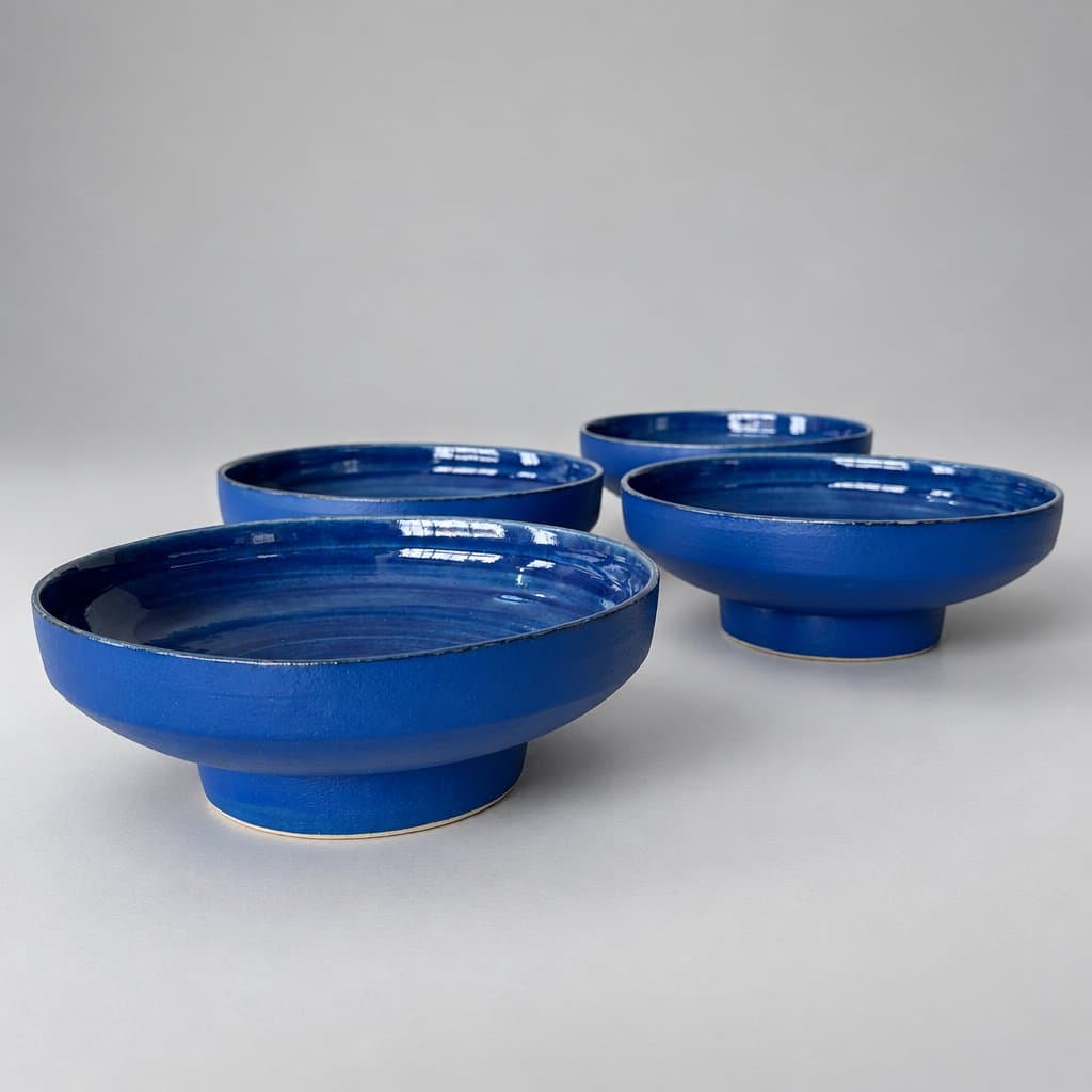 Four, footed, cream stoneware ice cream bowls in matte and glossy electric blue